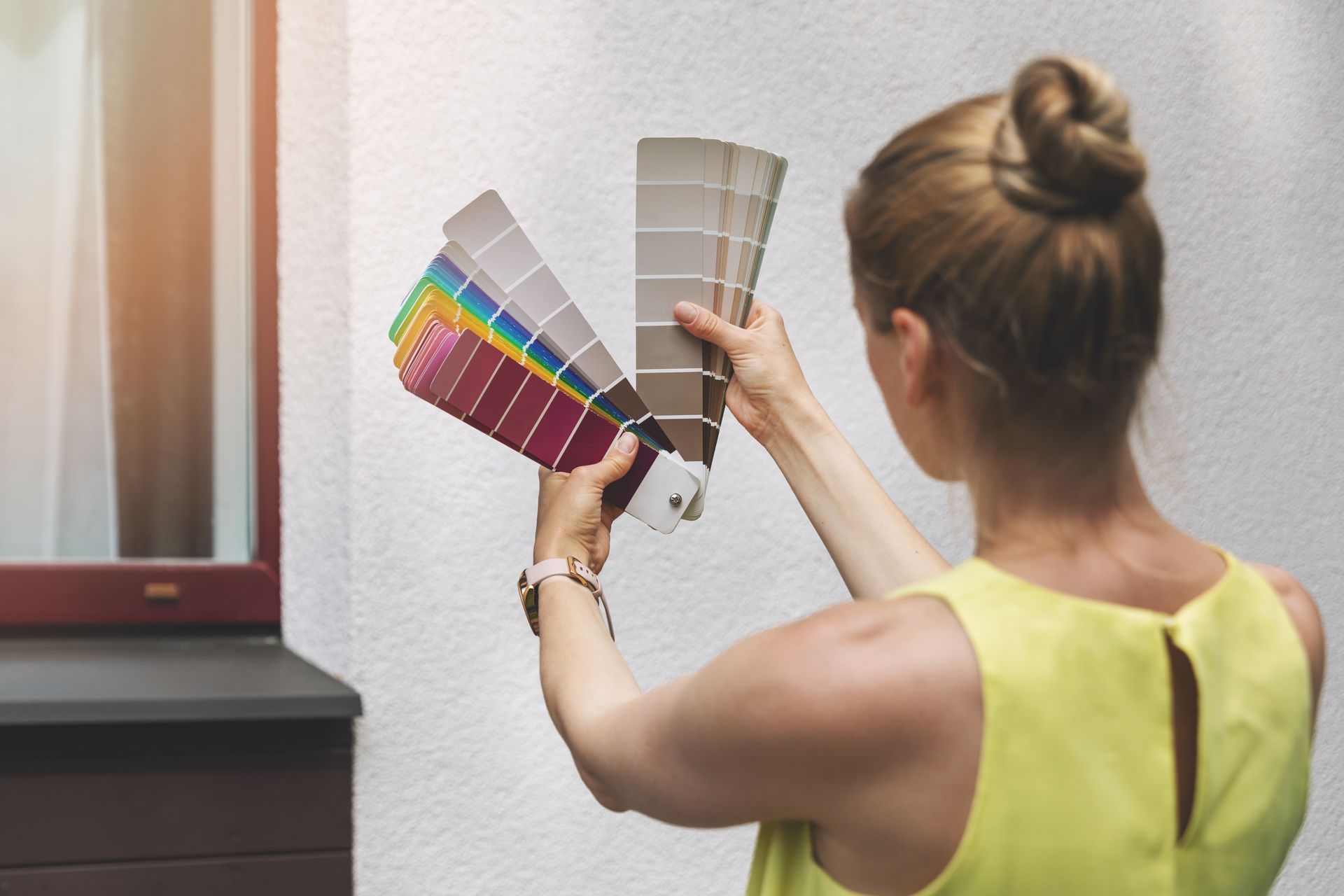 Femme choisissant la couleur de peinture de sa façade.