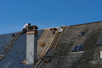 Couvreur remplacement les ardoises sur un toit.
