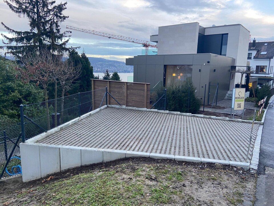 Ein grosses Haus mit einem Zaun und einer Betonauffahrt davor. Foto von der RRB GmbH