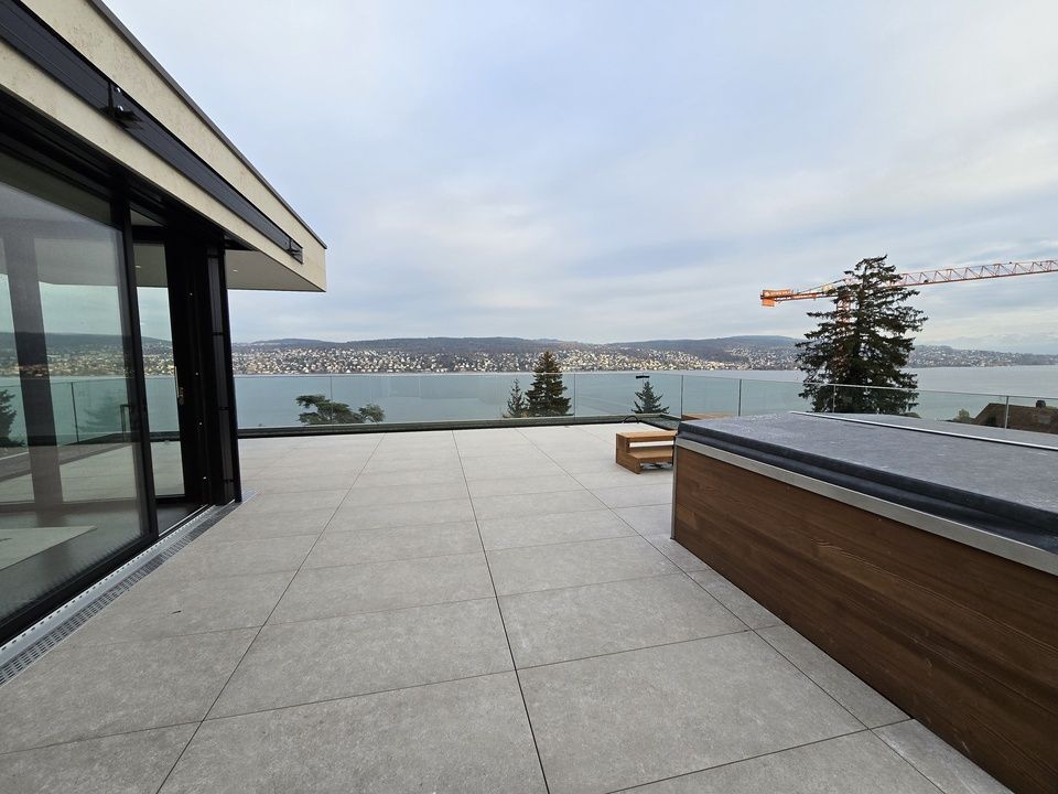 Eine Terrasse mit Whirlpool und Blick auf See. Foto von der RRB GmbH