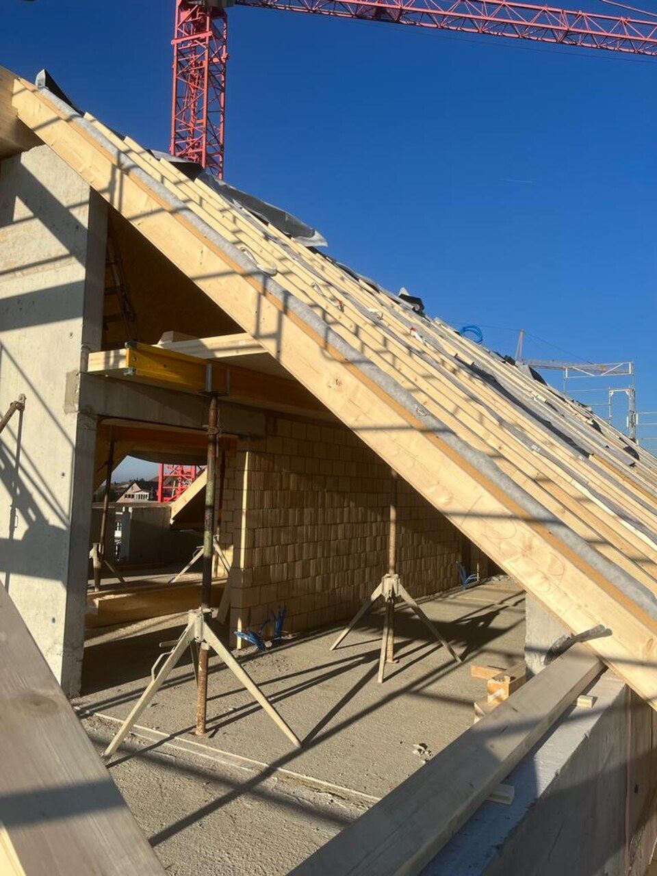 Ein im Bau befindliches Gebäude mit einem Kran im Hintergrund. Foto von der RRB GmbH