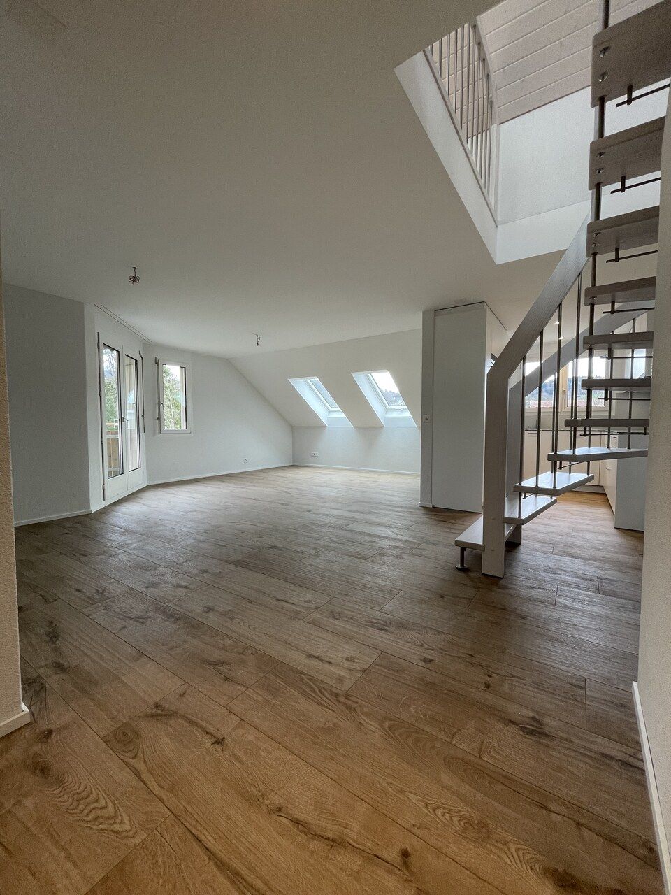 Ein leerer Raum mit Holzboden und Treppe. Foto von der RRB GmbH