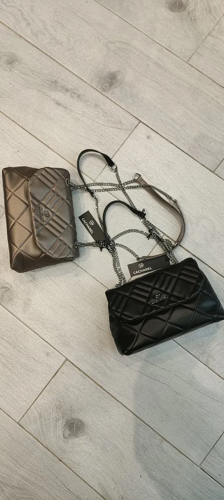 Dos bolsos están sobre un suelo de madera.