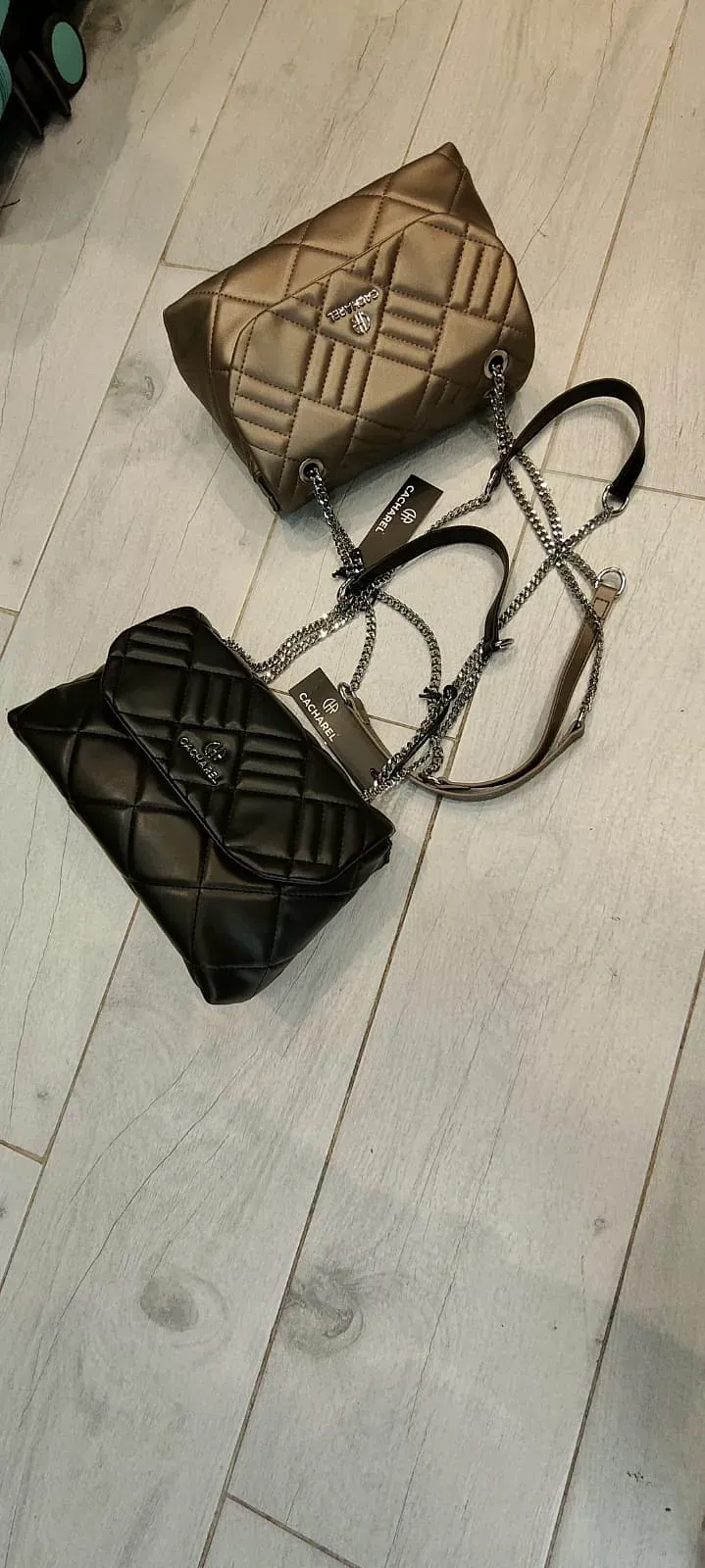 Dos bolsos están sobre un suelo de madera.