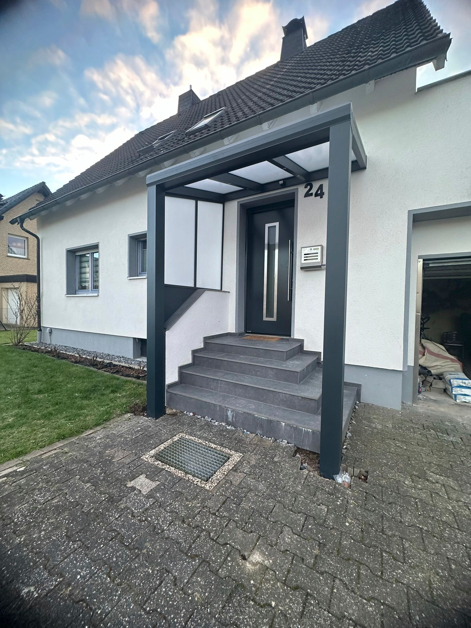 Ein weißes Haus mit einer schwarzen Veranda und Treppe.