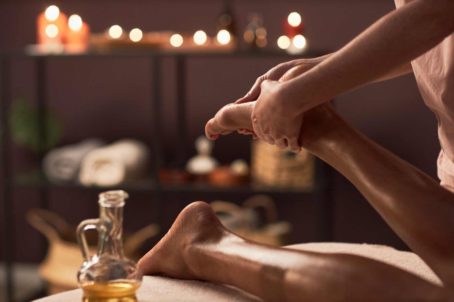 Hawaiianische Massage wird auf einer Frau durchgeführt - Auf dem Bild werden gerade die Füße massiert