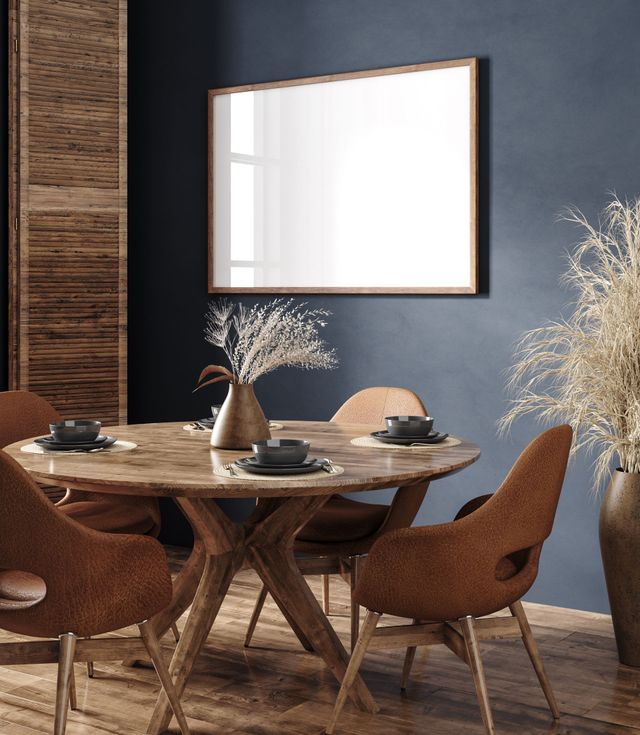 Une salle à manger avec une table et des chaises et un miroir au mur.