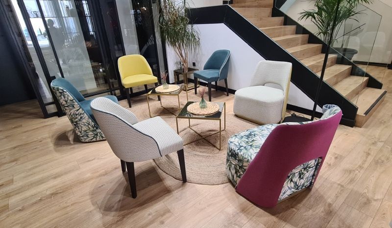 Un groupe de chaises sont placées en cercle dans une pièce à côté d'un escalier.