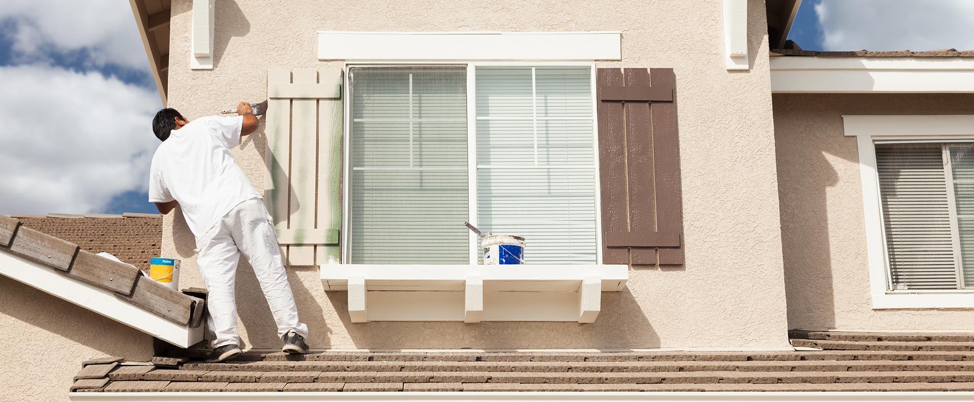 Artisan qui peint des volets