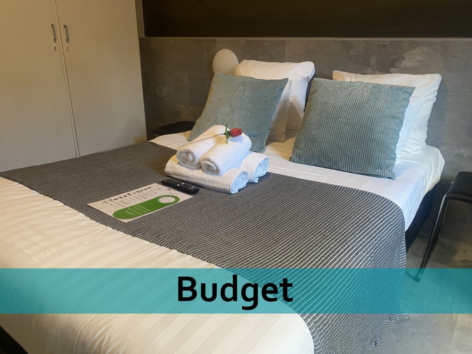Een hotelkamer met een bed en een bordje met de tekst budget