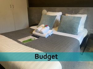 Een hotelkamer met een bed en een bordje met de tekst budget.
