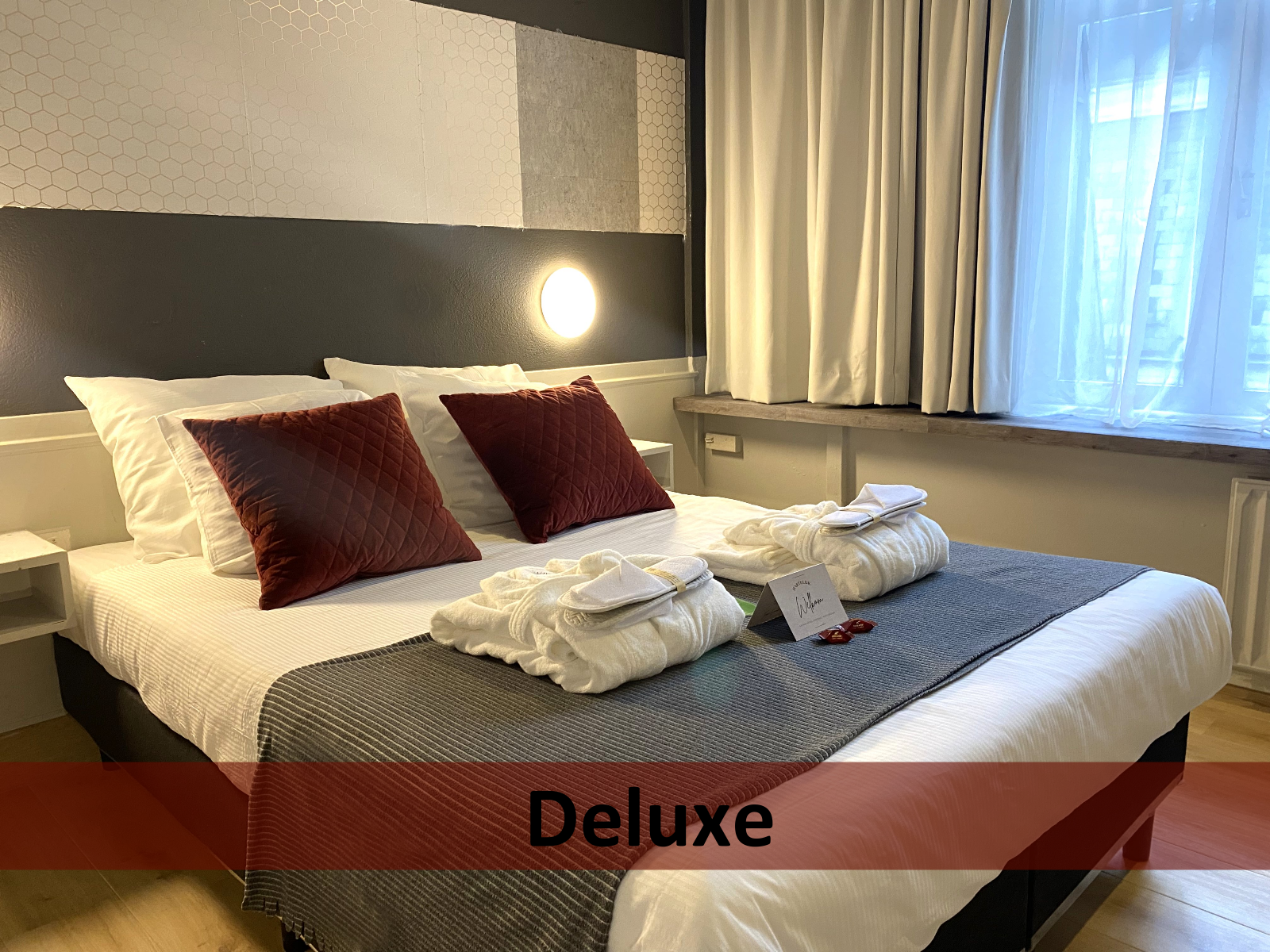 Een hotelkamer met een luxe bed en rode kussens