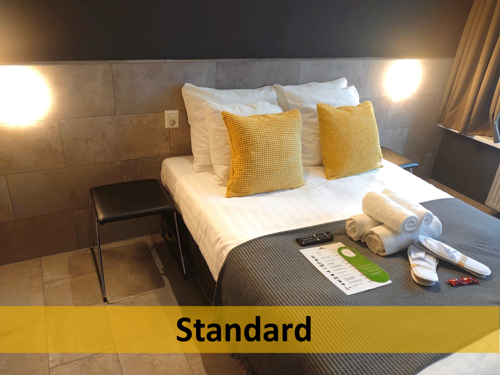 Een hotelkamer met een bed en een bordje met de tekst standaard