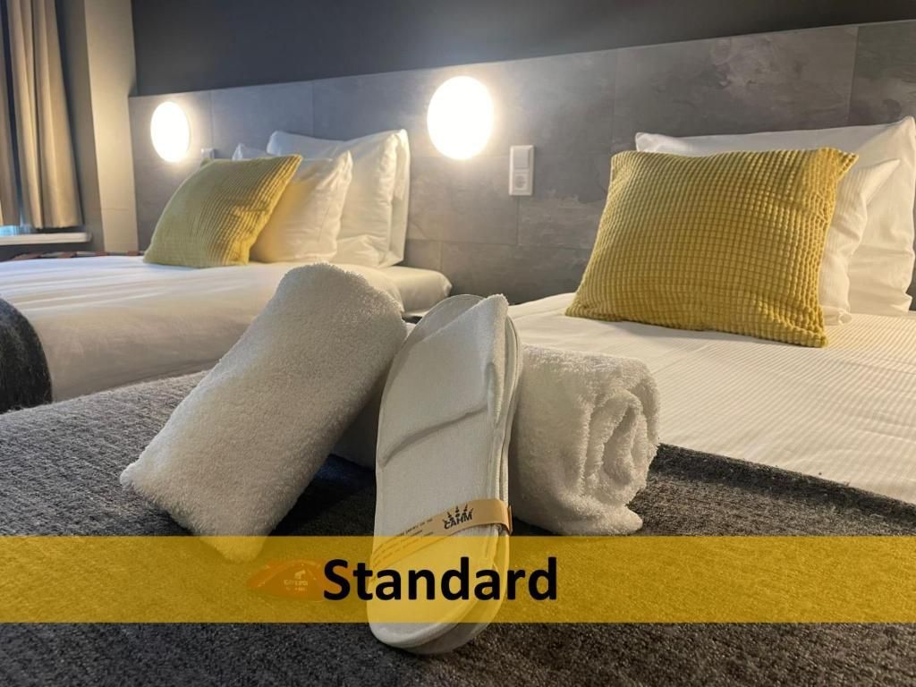 Een hotelkamer met twee bedden en handdoeken op het bed.