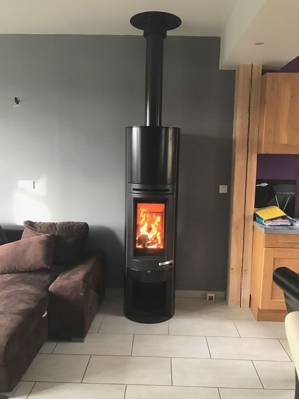 Poêle à bois installé dans un salon au murs gris