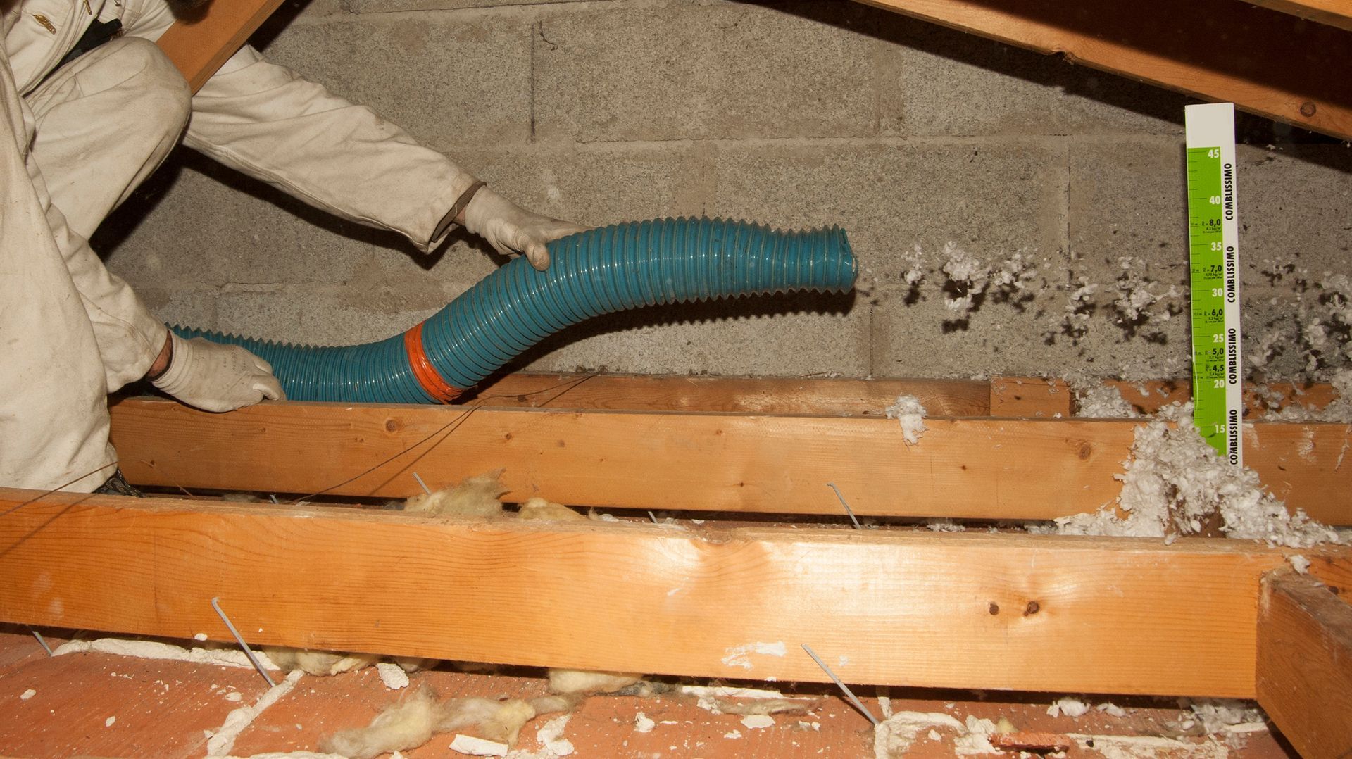 Soufflage de laine minérale entre les poutres d'une charpente