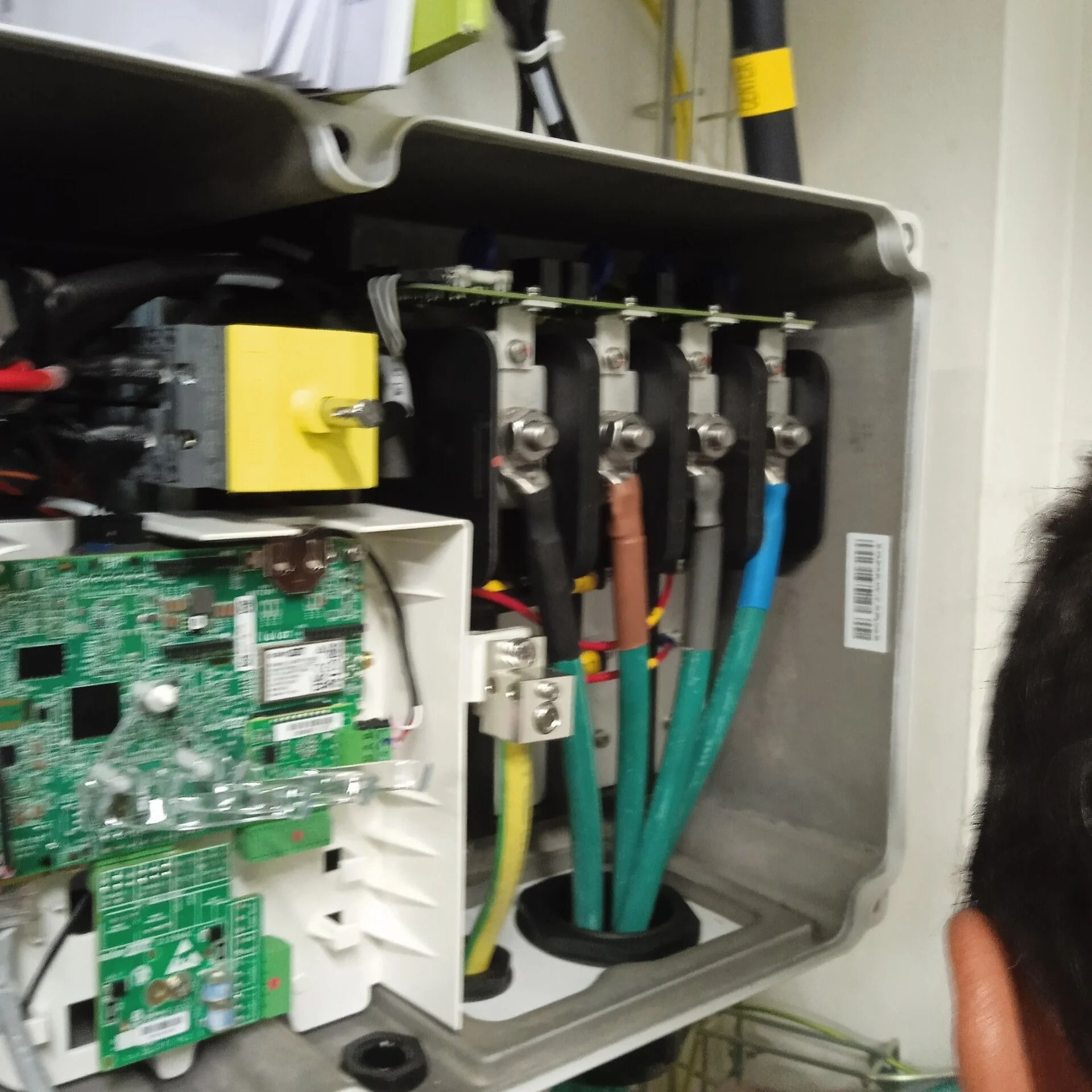 Panel de control eléctrico abierto con placas de circuitos, cables y bloques de terminales.