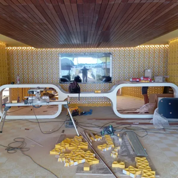 Escritorio moderno, blanco y de forma ovalada y paredes con dibujos amarillos bajo un techo de listones de madera.