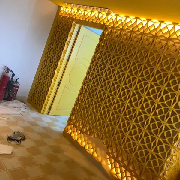 Biombo divisorio de ambientes enrejado amarillo con cálida iluminación LED integrada cerca de una puerta amarilla.