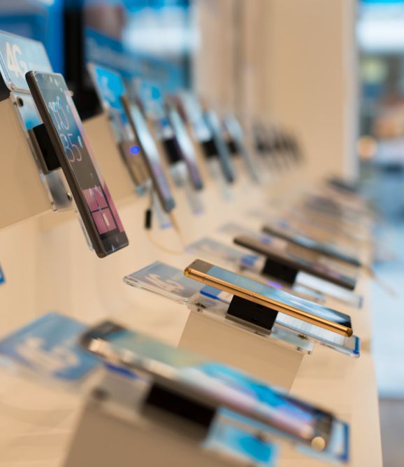 Una fila de teléfonos móviles en exhibición en una tienda.