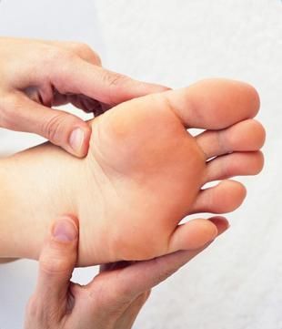 Una persona sostiene la mano y el pie de un niño.