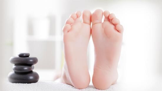 Un primer plano de los pies de una persona junto a una pila de rocas.