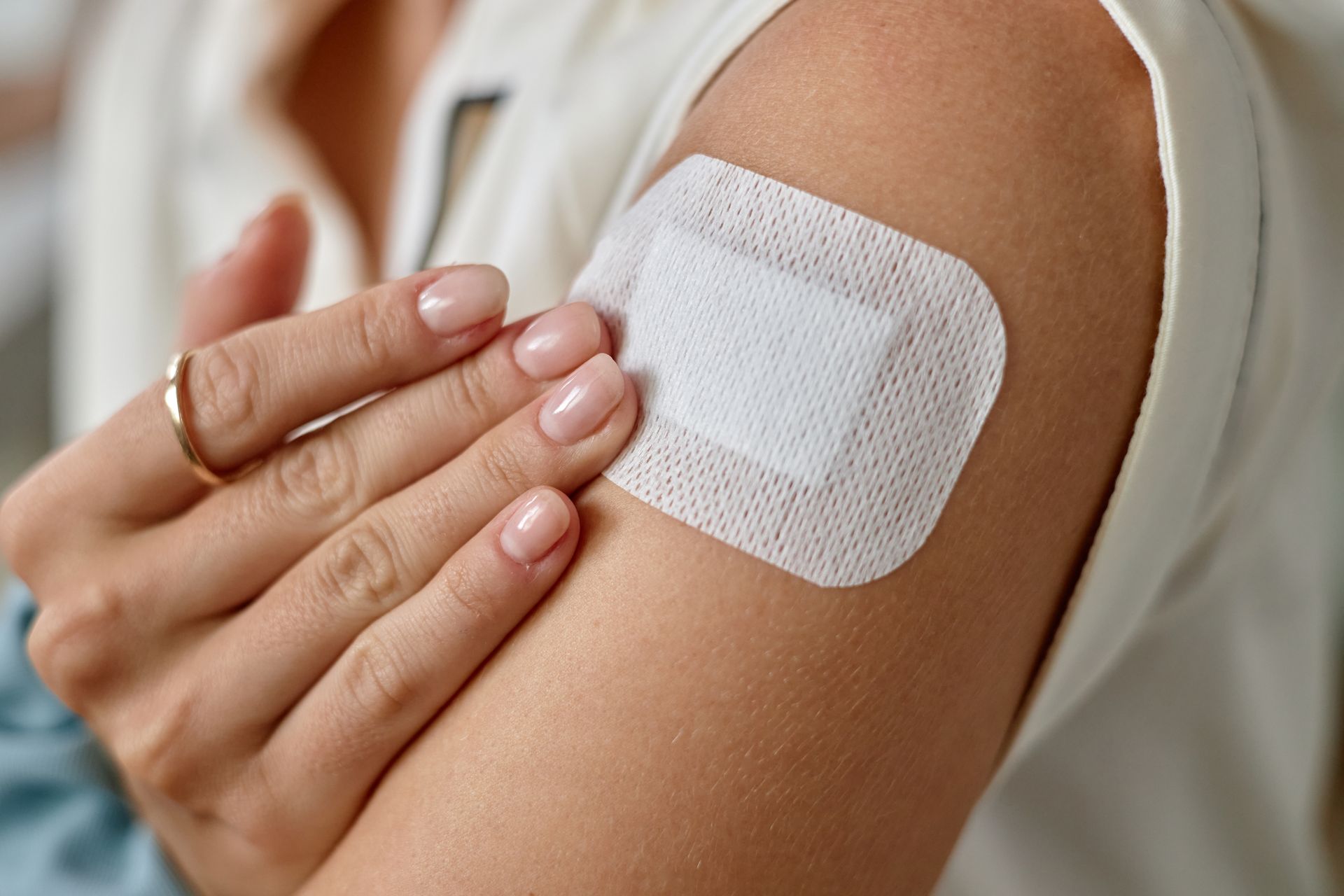 Pansement adhésif appliqué sur le bras après une injection ou une vaccination