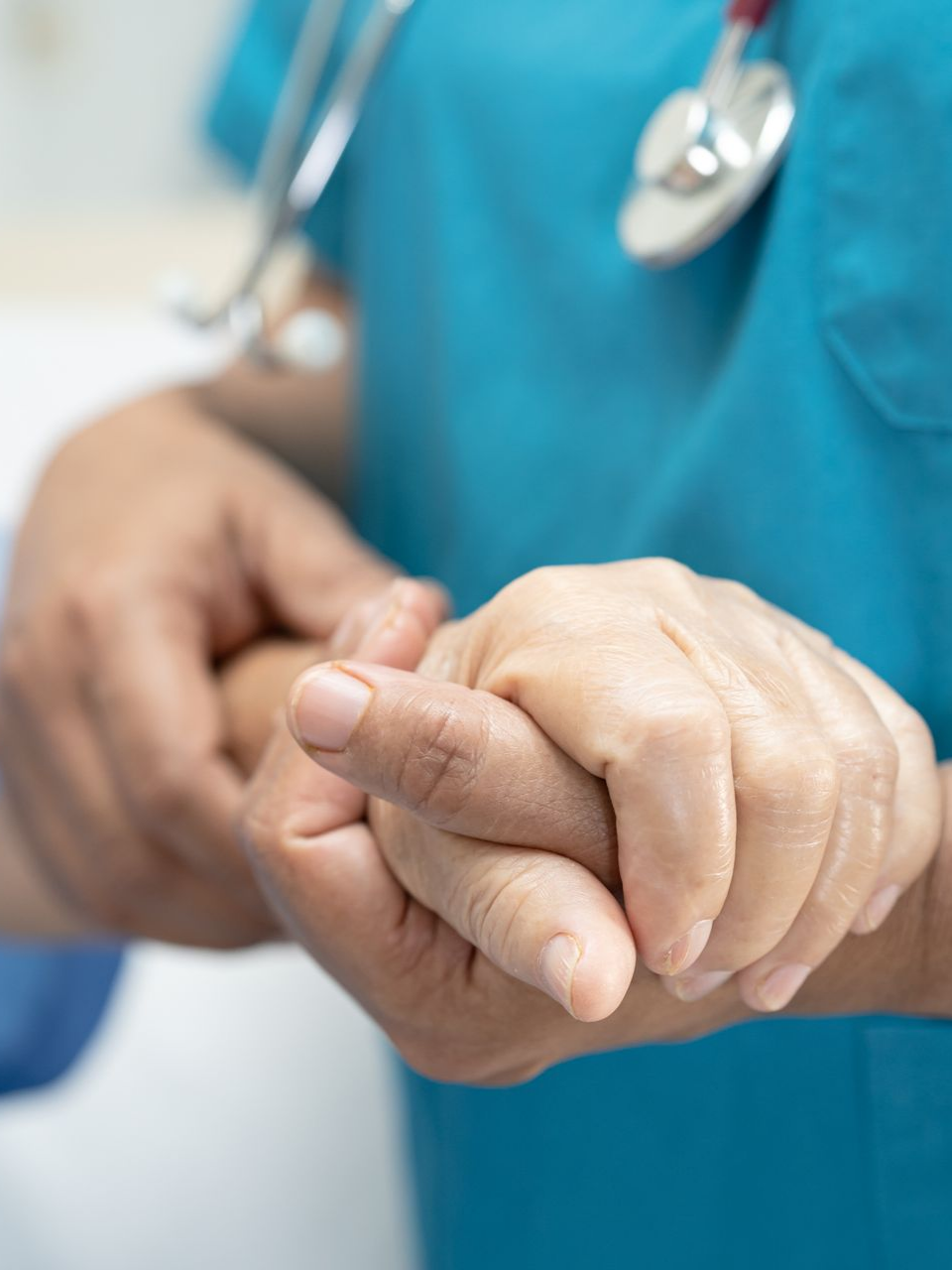 Infirmier tenant la main d'un patient