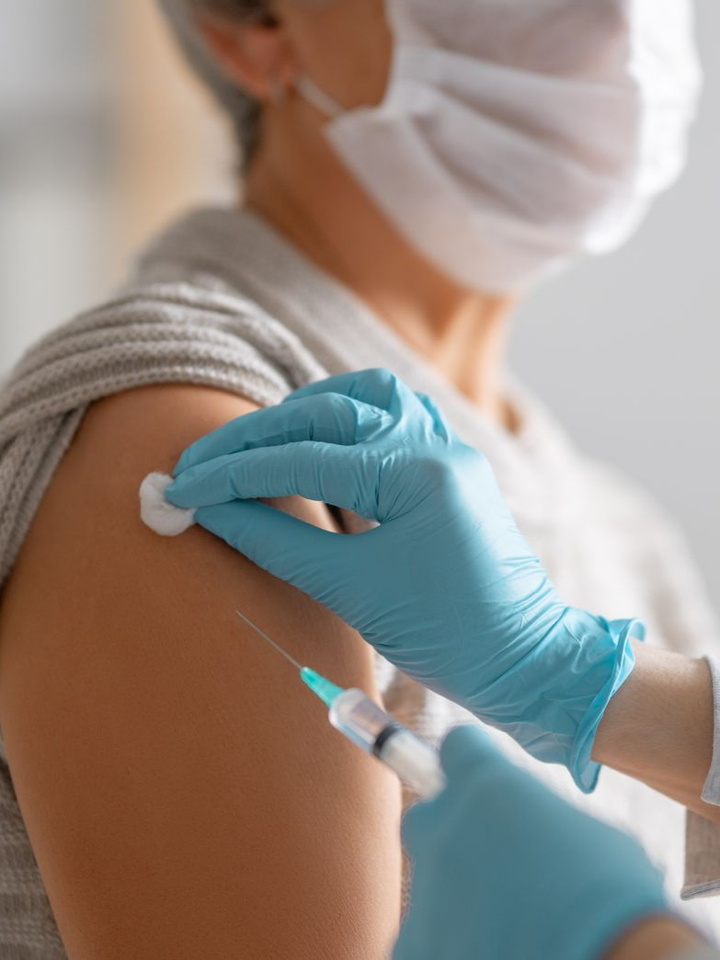 Personne de profil en train de se faire vacciner