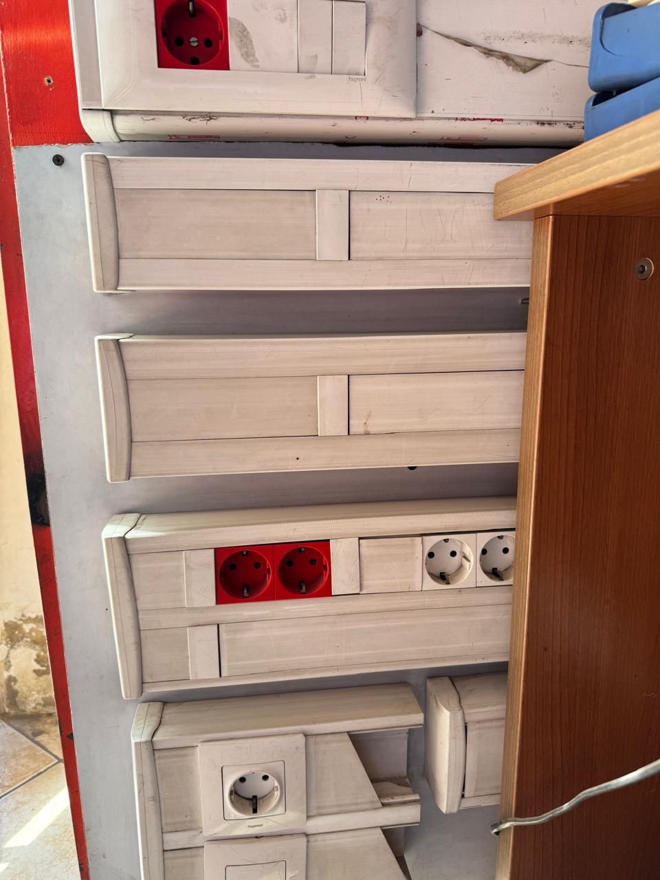 Tomadas elétricas em caixas brancas, com predominância das cores vermelha e branca.