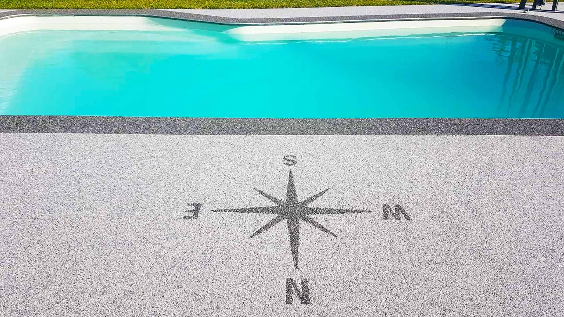 Décoration en boussole dans résine devant piscine.