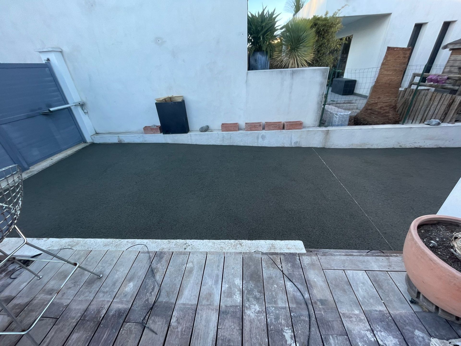 Terrasse extérieure en résine récemment posée avec bordure en bois.