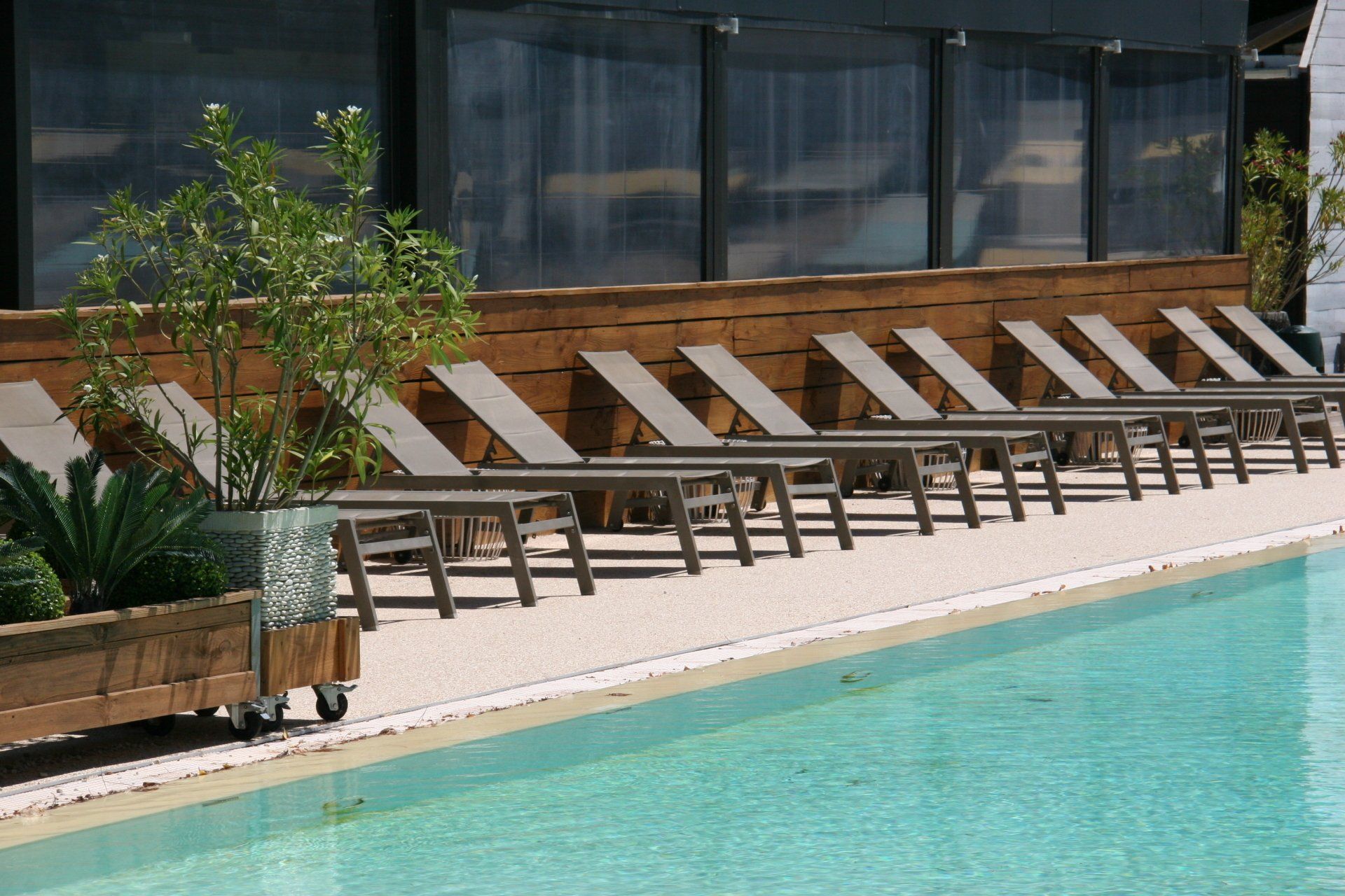 Résine drainante coulée autour d'une immense piscine privée d'un hôtel.