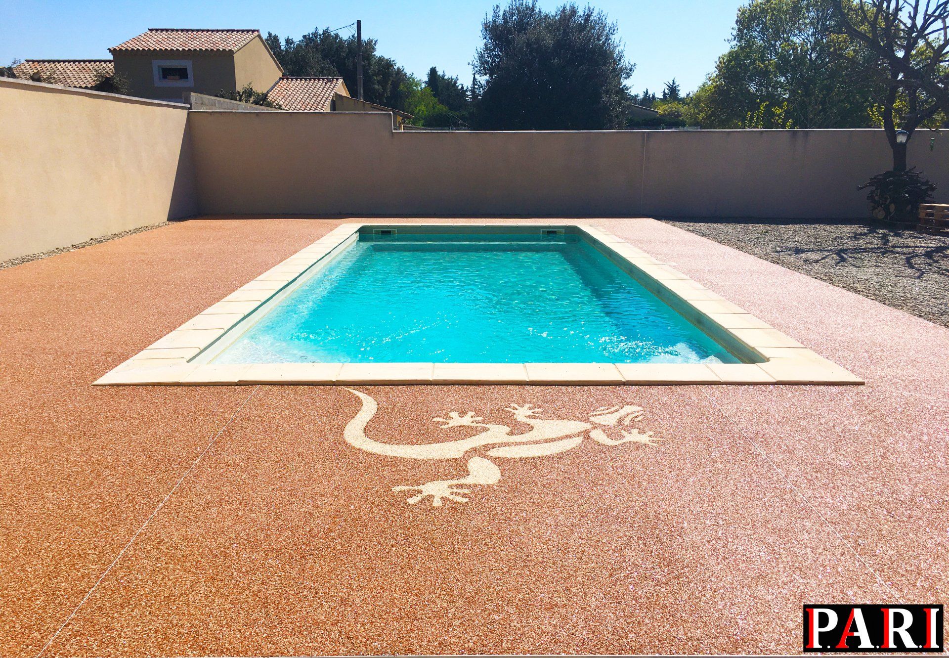 Résine drainante avec motif décoratif en forme de lézard coulée devant piscine creusée.