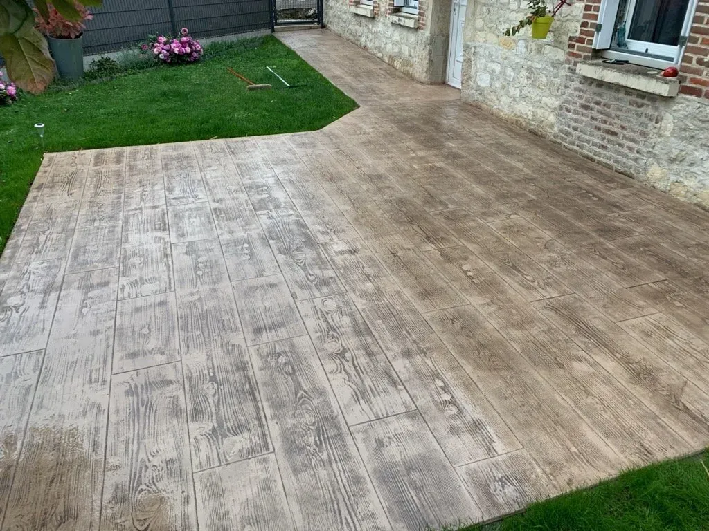 Sol de terrasse en béton imprimé marron, aspect bois.