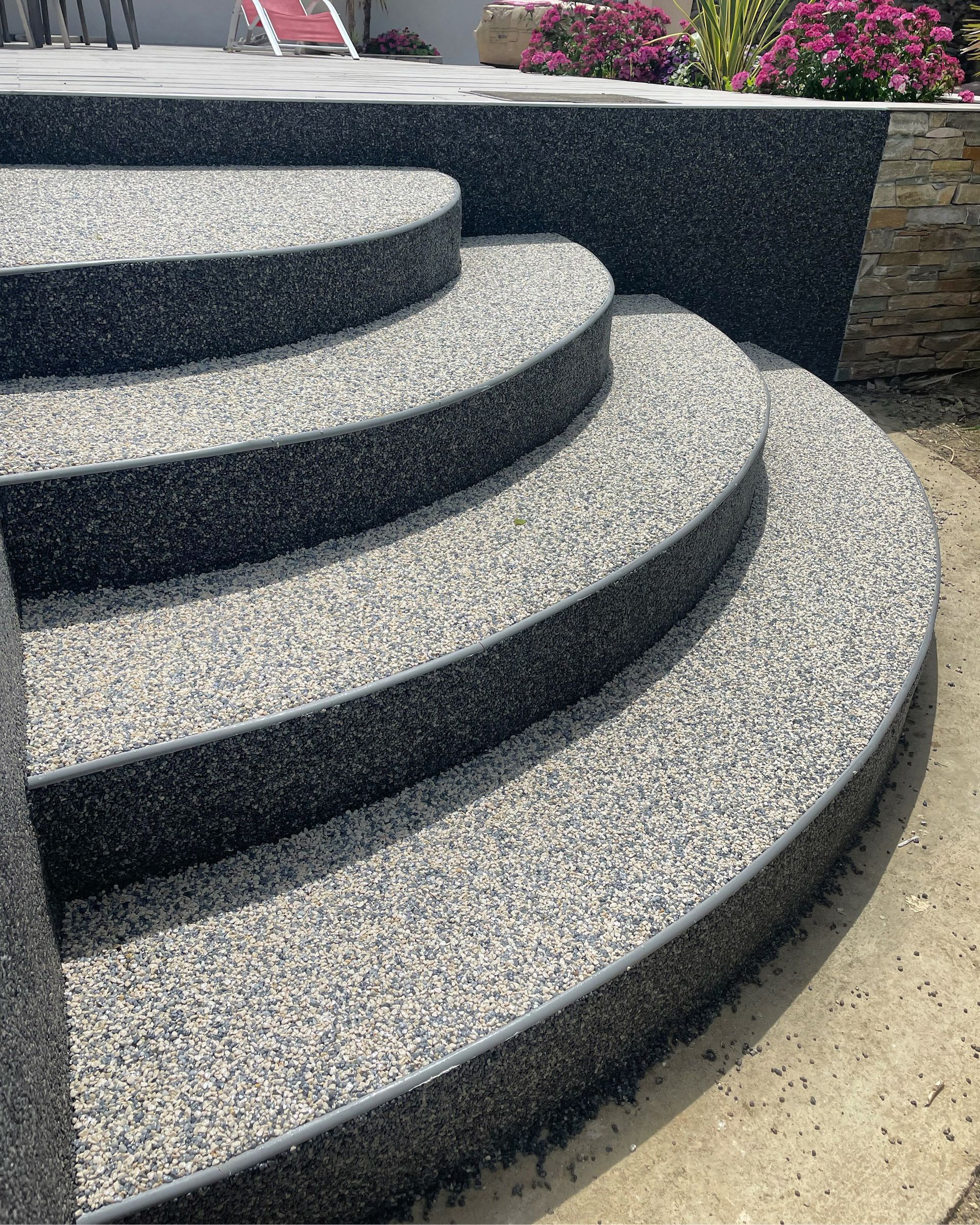 Escalier extérieur en gravier avec des marches incurvées.