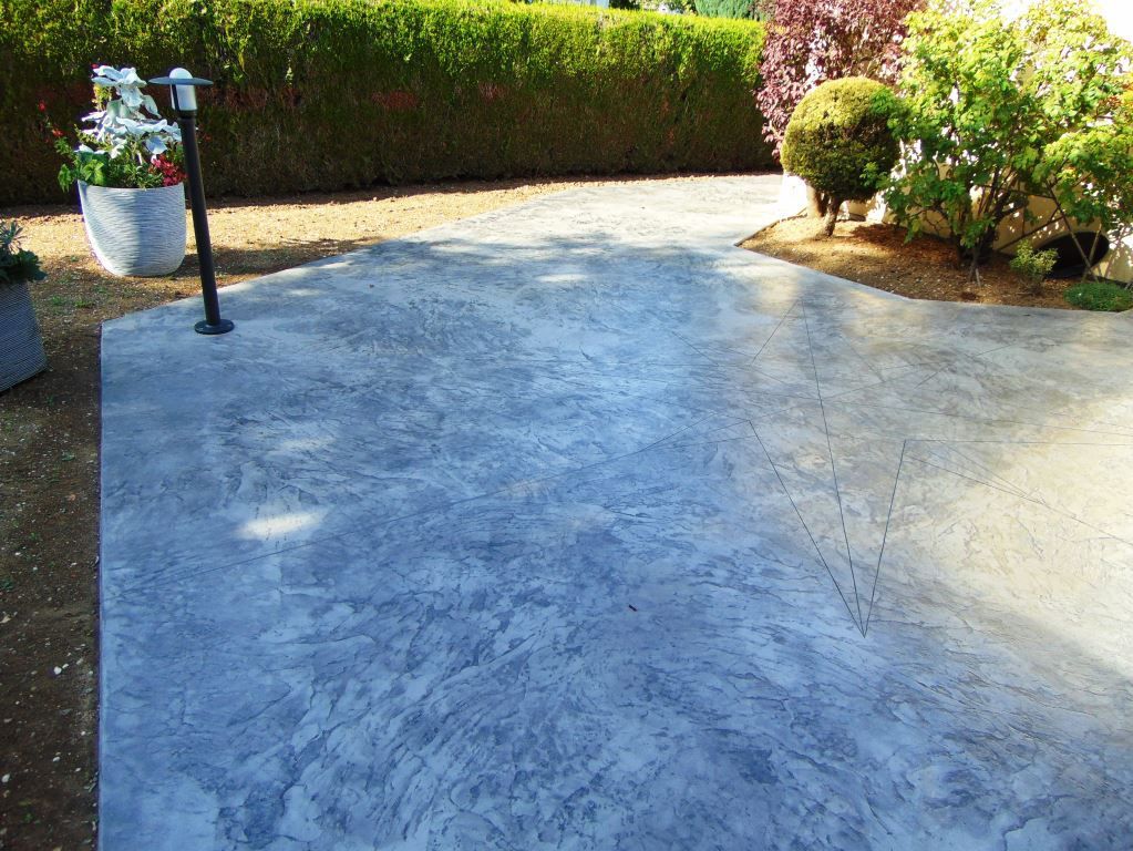 Béton imprimé au motif étoilé gris brossé dans cours extérieure.