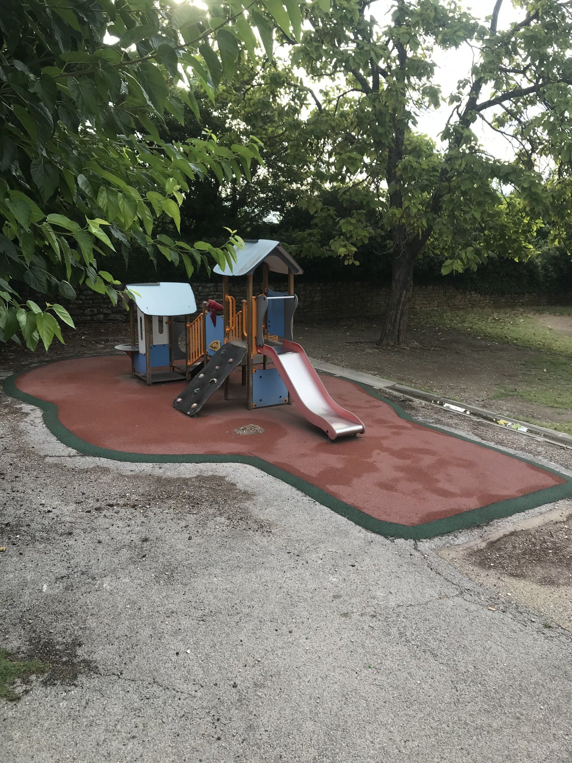 Résine amortissante coulée sous installation avec toboggan pour enfants.