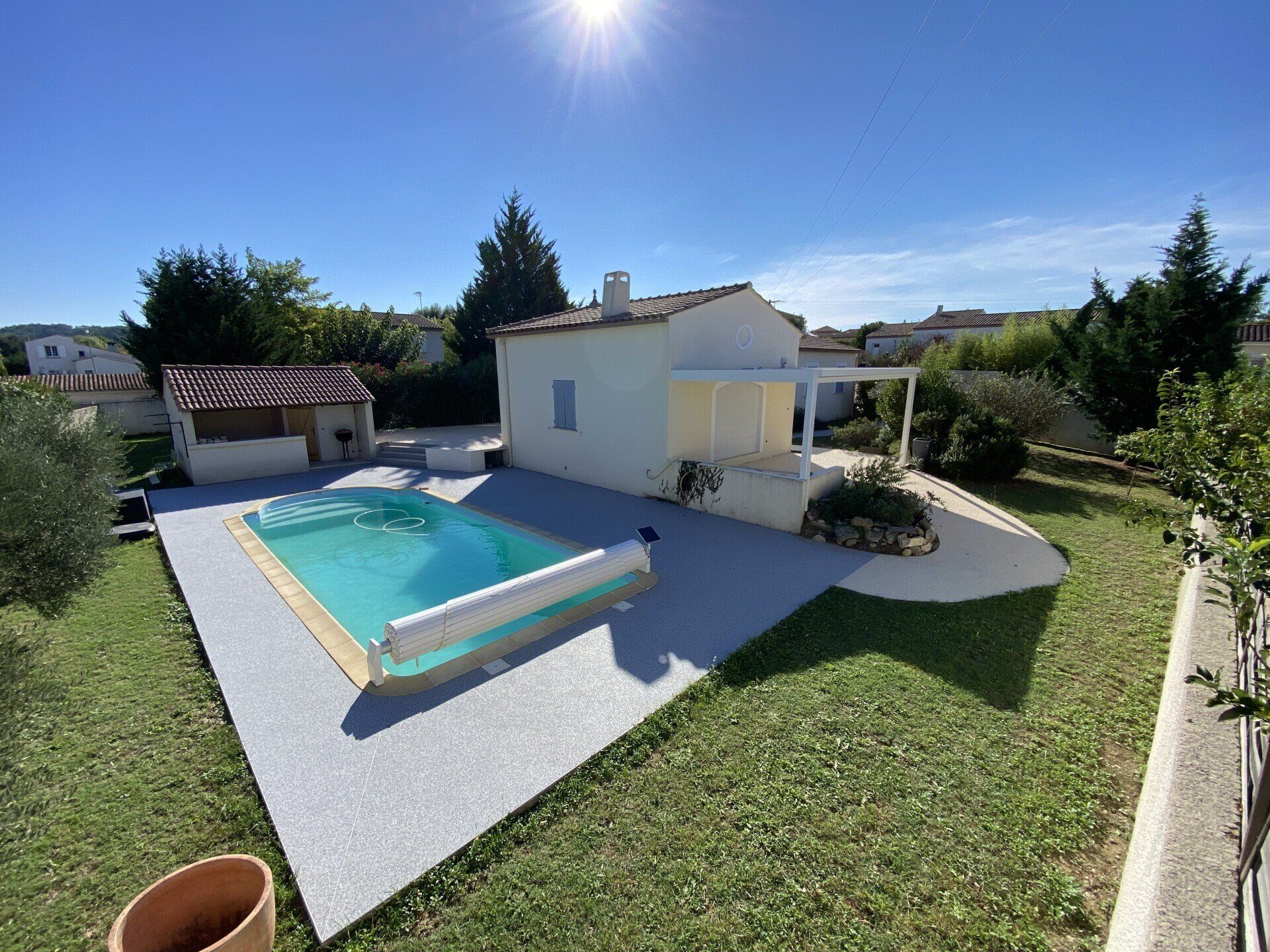 Super jardin avec piscine creusée, la résine drainante coulée autour de la piscine et de la maison.