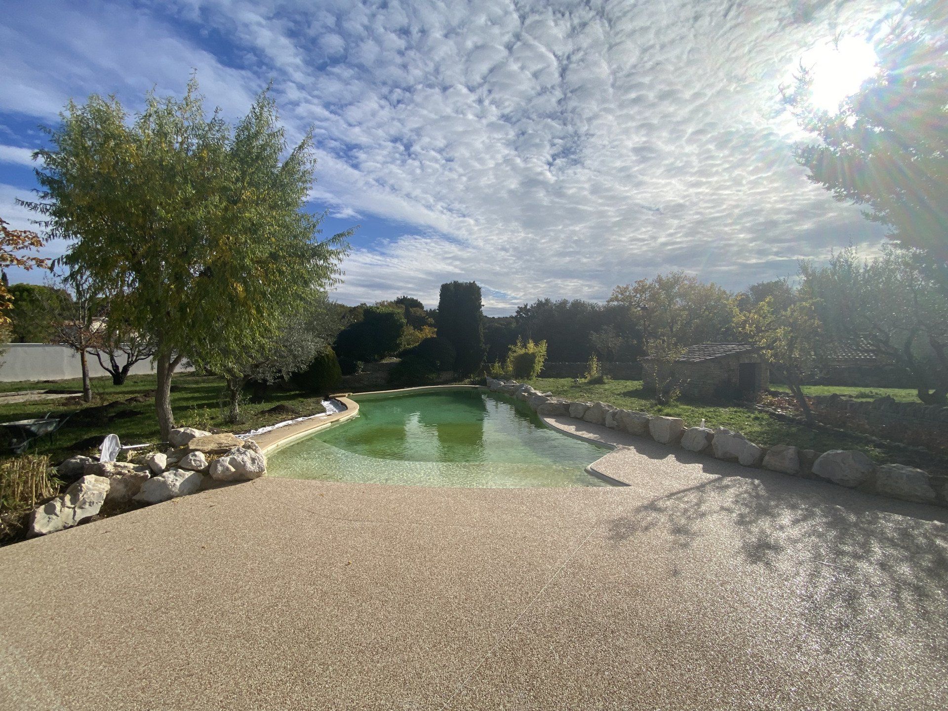 Résine drainante sur une terrasse entourant une piscine creusée.