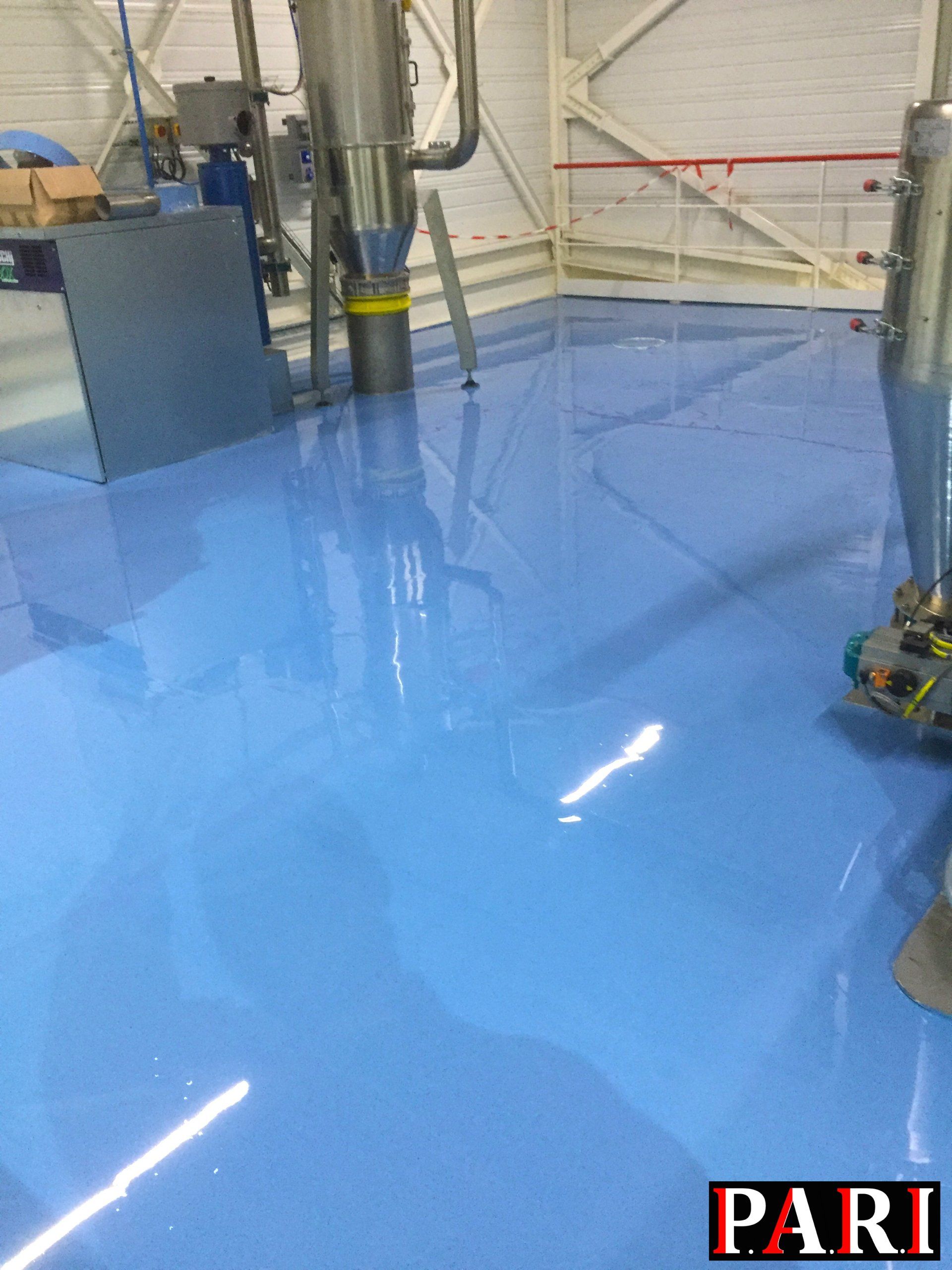 Sol en résine bleue brillante dans un espace intérieur.