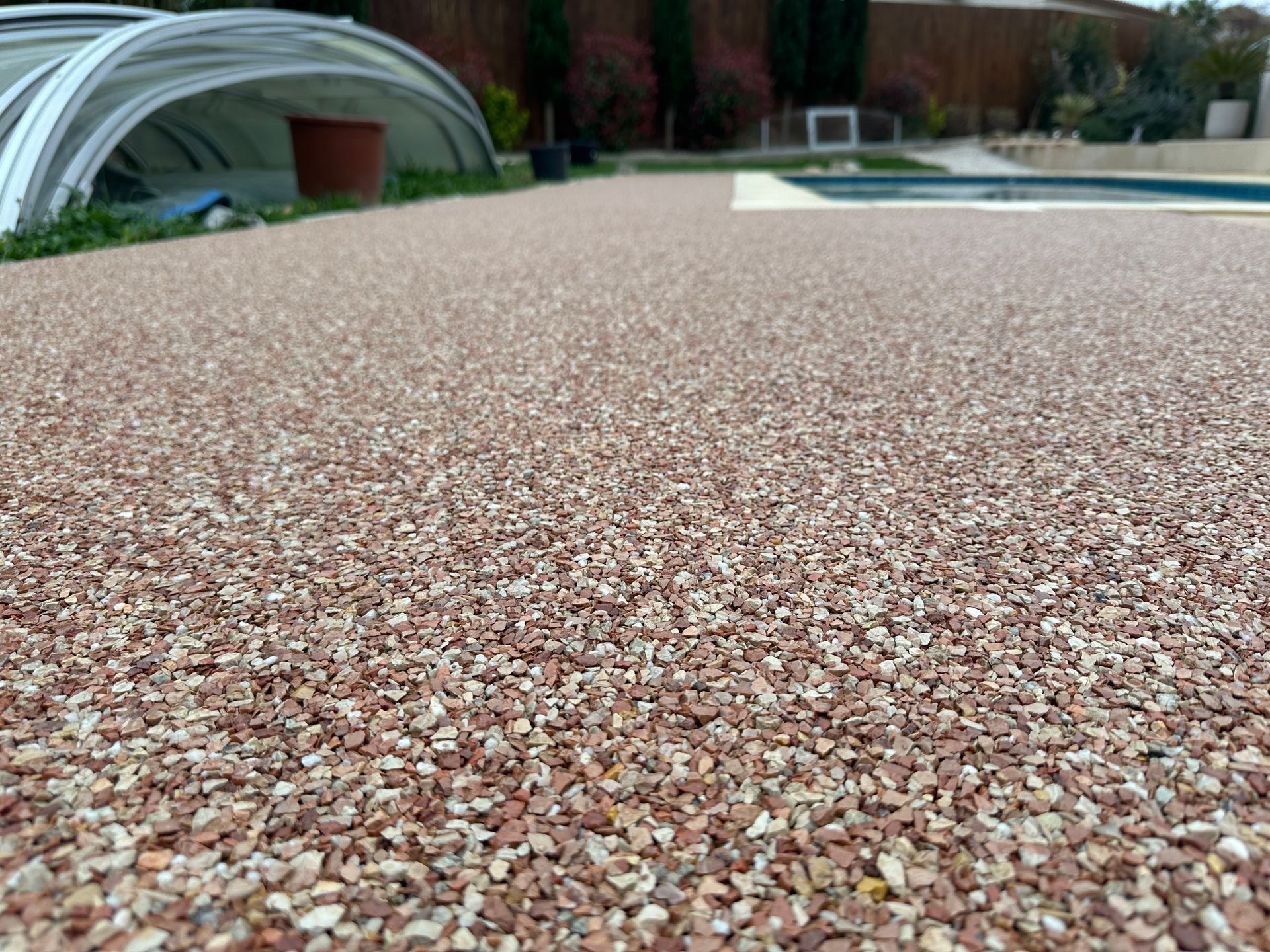 Surface extérieure en gravier fin avec des nuances de brun et de gris.