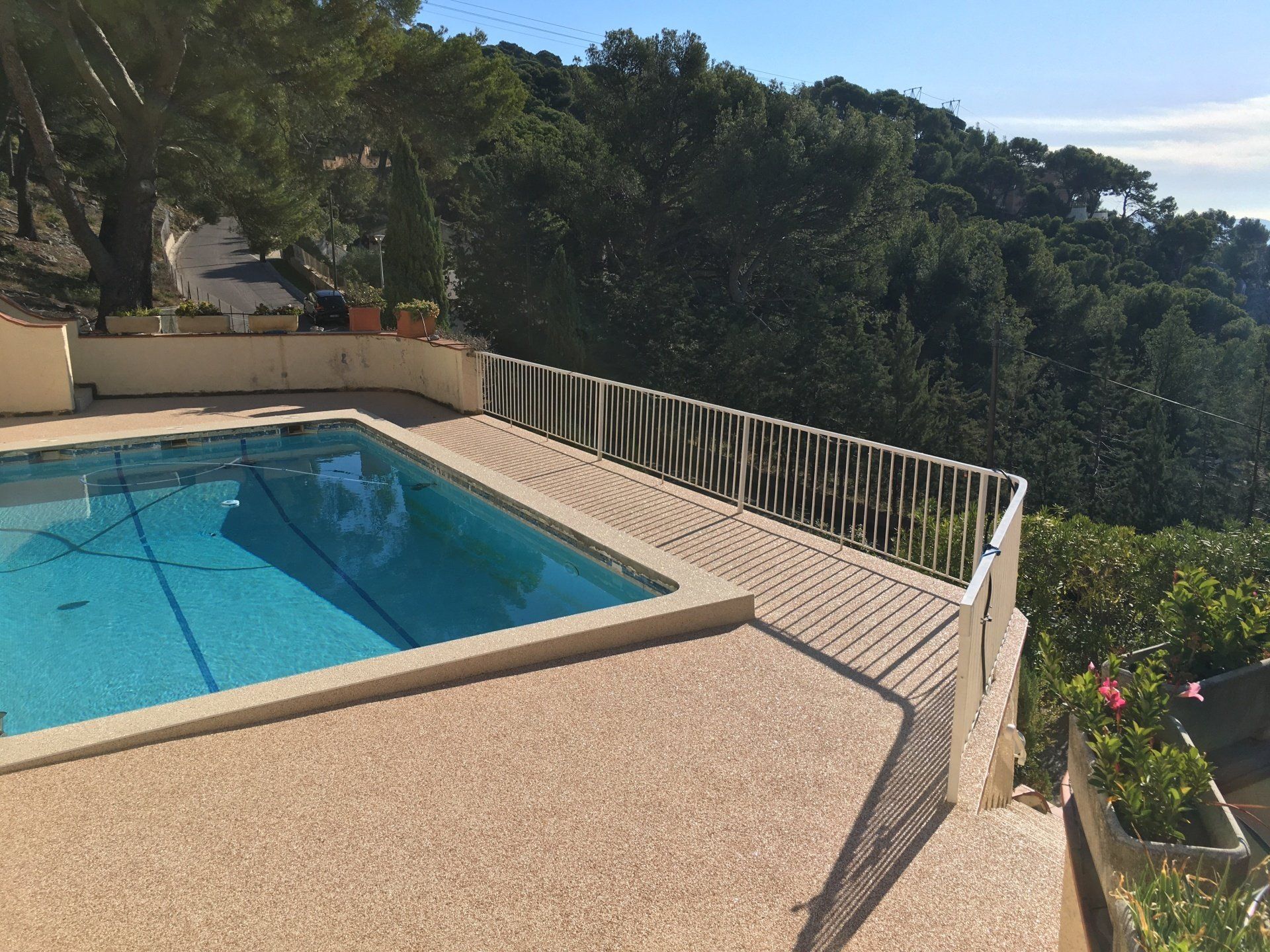 Résine drainante autour d'une piscine creusée avec vue sur la vallée.