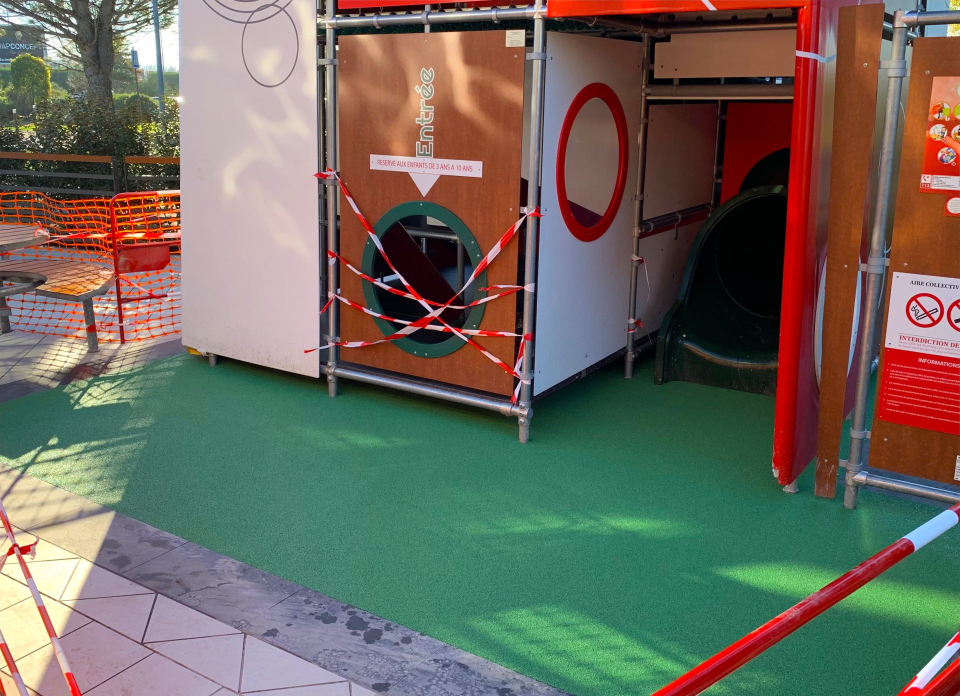 Gros plan sur aire de jeux pour enfants, résine amortissante coulée au sol.