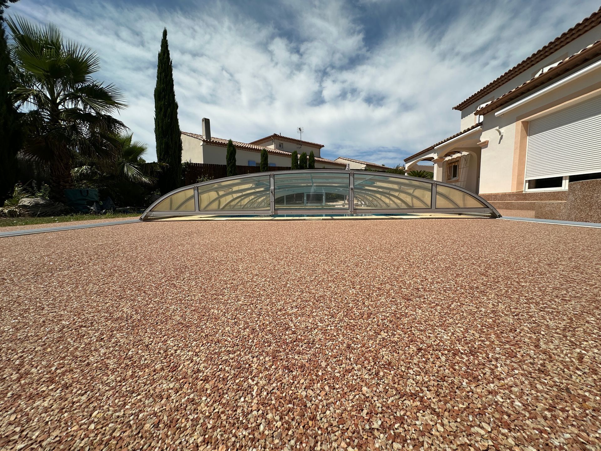 Moquette de pierre de couleur marron autour d'une piscine couverte.