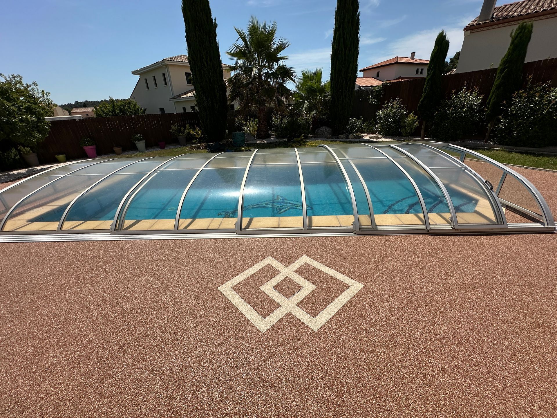 Sol en résine avec décoration dessinée dedans devant piscine couverte.