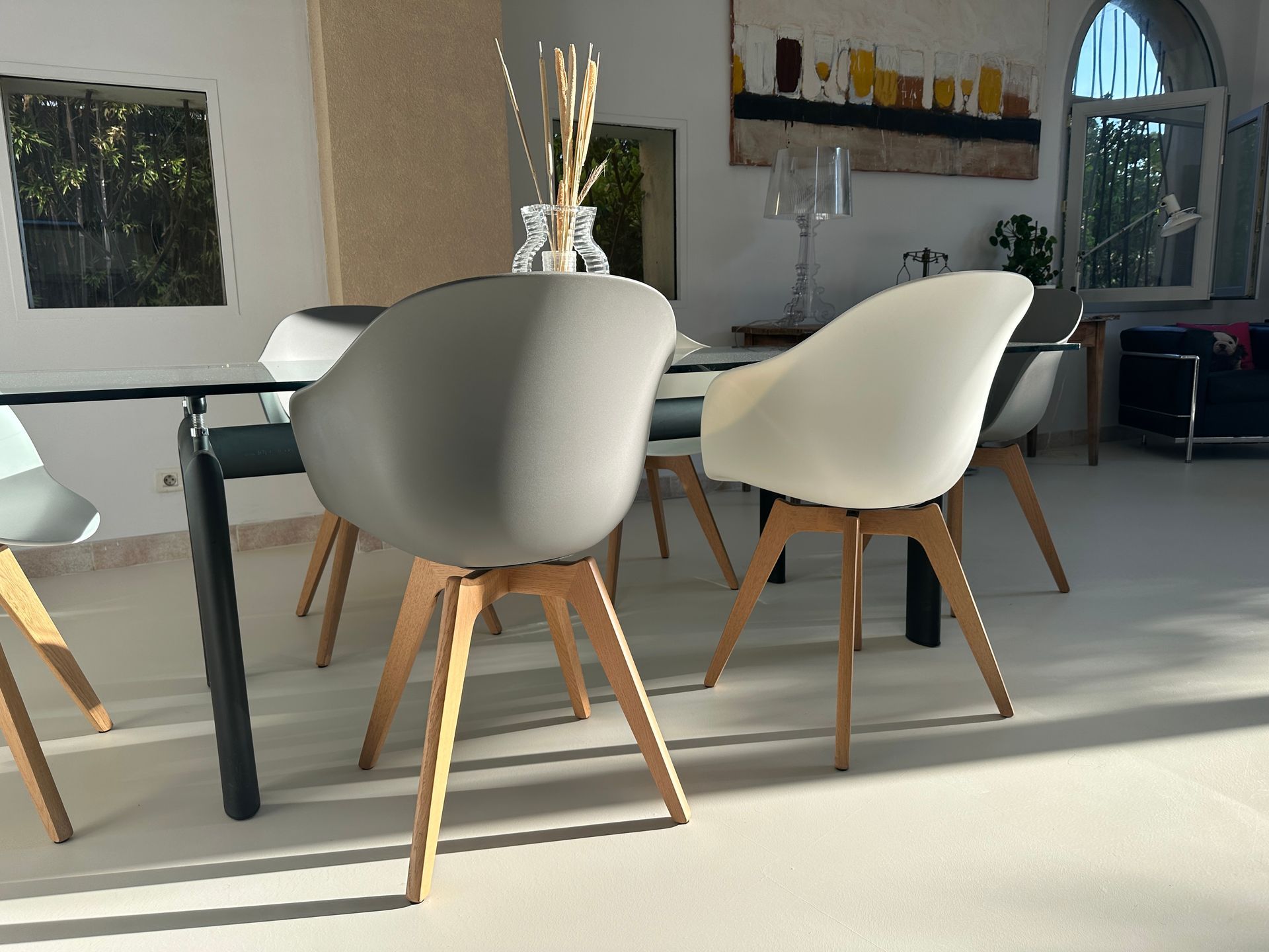 Coin repas extérieur avec table et chaises design sur sol en résine.