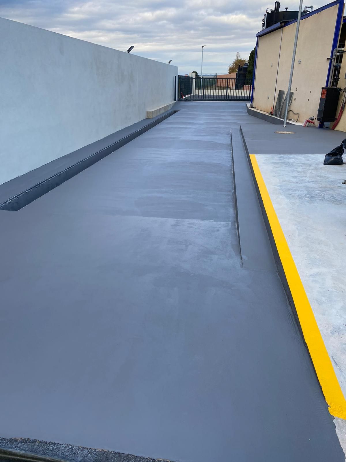 Sol en béton lisse avec une ligne jaune peinte au centre.