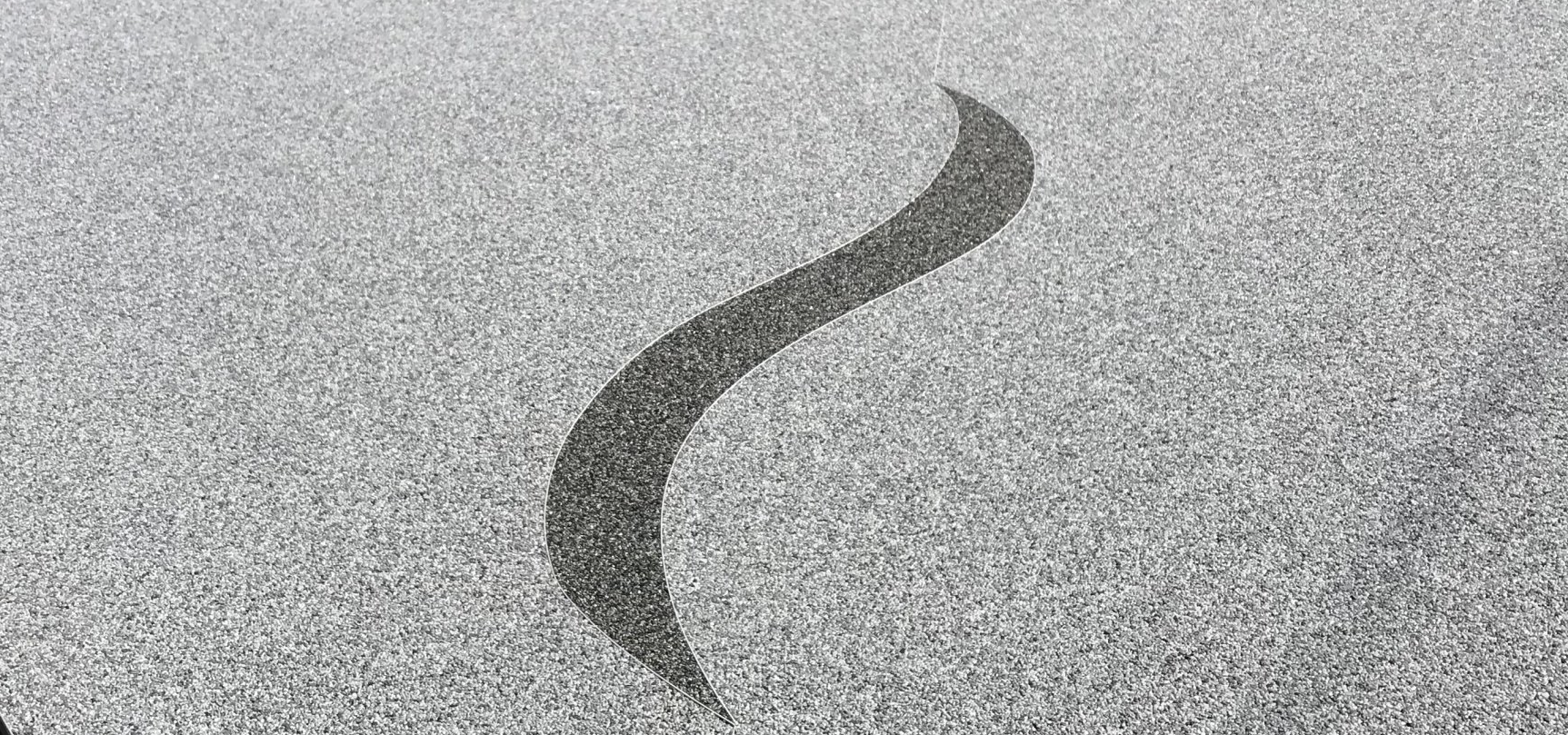 Focus sur un logo fait en résine décorative, couleurs gris et anthracite du plus bel effet.