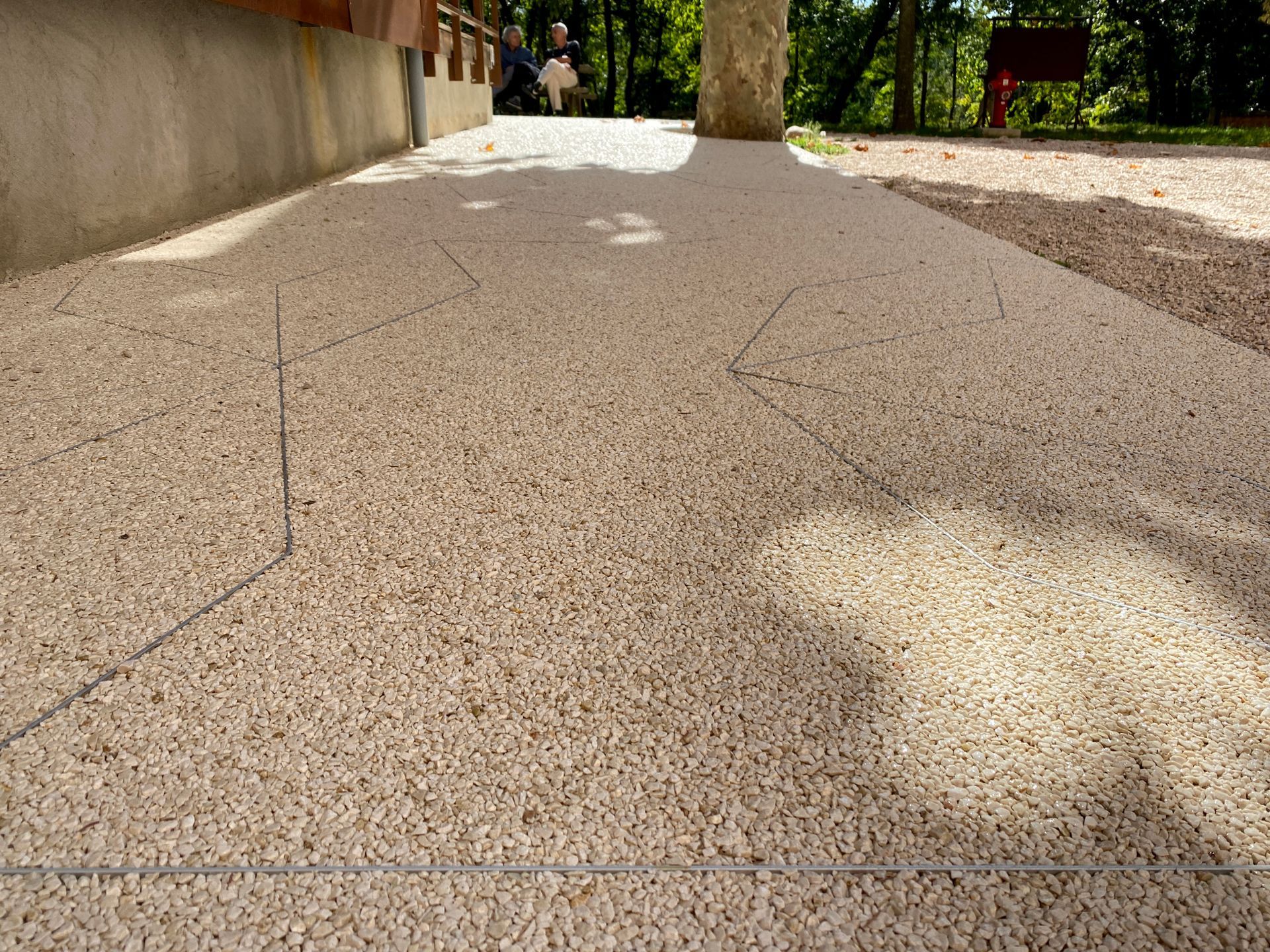 Surface en gravier fin avec des formes géométriques.